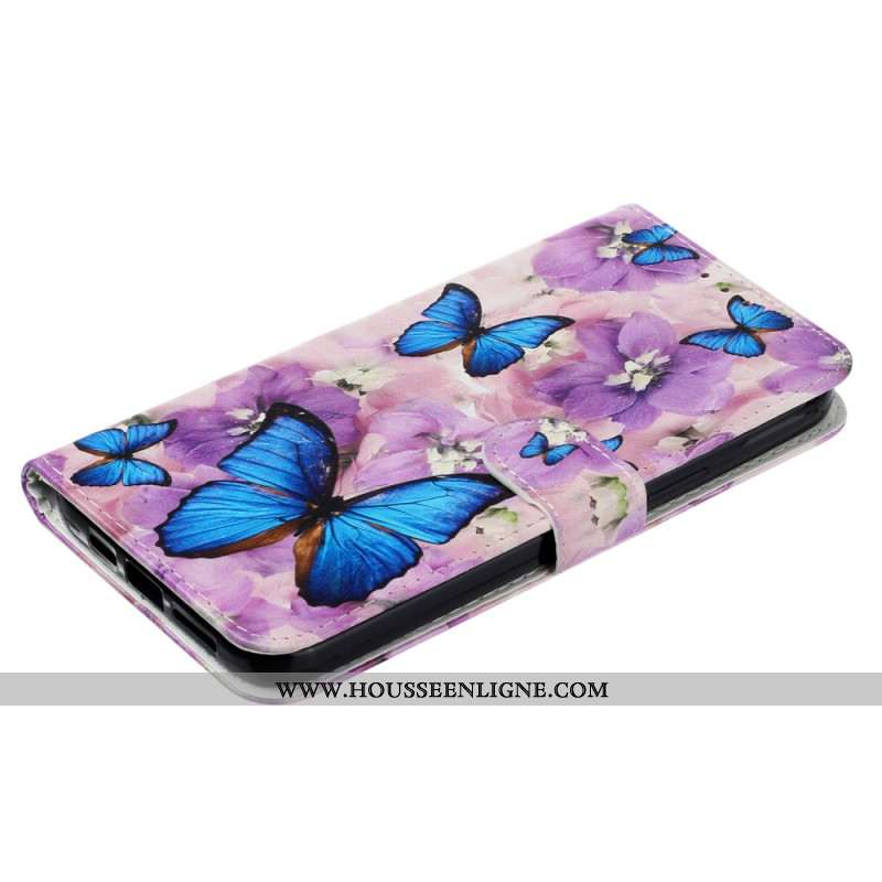 Housse iPhone 16 Papillons Bleus et Fleurs Violettes à Lanière